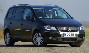 Czarny Volkswagen Touran 2004 z kierowcą w kapturze, widok z przodu.