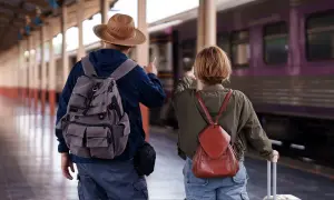 Para, plecak i walizka czekają na pociąg nad morze.
