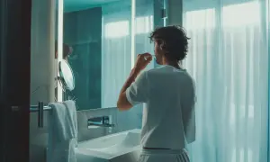 Mężczyzna w łazience szczotkuje zęby, dbając o świeży zapach z ust.