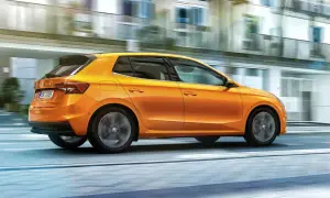 En orange Skoda Fabia kör snabbt genom staden. Inga problem med denna bil, bara ren körglädje.