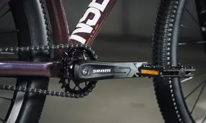Zbliżenie na rowerowy mechanizm korbowy SRAM i łańcuch. Tabela przełożeń rowerowych jest kluczowa dla optymalnego pedałowania.