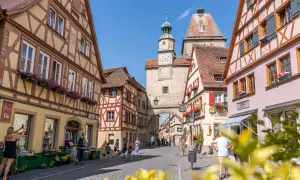 Entdecke die charmanten Gassen von Rothenburg ob der Tauber. Geheimtipps für deinen Besuch: Fachwerkhäuser, ein Marktplatz mit Uhrturm und blumengeschmückte Fenster.