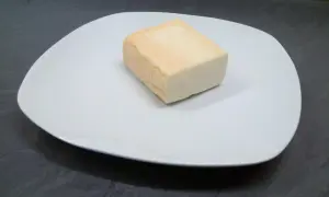 Kawałek sera taleggio na białym talerzu. Czy taleggio to dobry wybór na przekąskę?