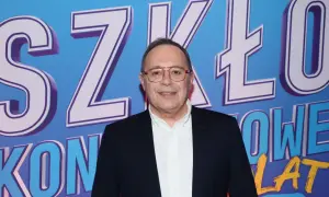 Uśmiechnięty mężczyzna w okularach na tle napisu "SZKŁO KONTAKTOWE OBSADA".
