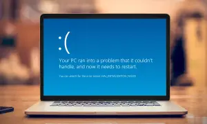 Niebieski ekran błędu Windows z uśmiechniętą buźką i komunikatem o błędzie.