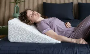 Woman sleeping on a wedge pillow. Learn how to make memory foam pillow expand faster for ultimate comfort.