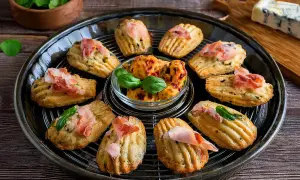 Délicieuses madeleines salées pour apéritif, garnies de jambon cru et de basilic. Parfaites pour une recette facile et gourmande.