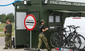 Strażnicy graniczni prowadzą kontrole graniczne Niemcy. Na posterunku stoi zielony kontener, obok niego funkcjonariusze i rowerzyści.