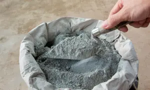 Łopata nabiera suchy beton pod kostkę. Właściwe proporcje to klucz do trwałej nawierzchni.