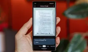 Telefon z aplikacją Obiektyw Google pokazuje, jak zeskanować zdjęcie dokumentu. Widoczne są ramki do dopasowania tekstu.