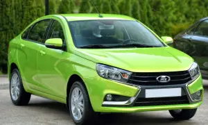 En ljusgrön Lada Vesta står parkerad utomhus.