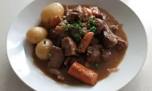 En härlig fransyska gryta med möra köttbitar, mjuka potatisar och saftiga morötter, toppad med färsk persilja.