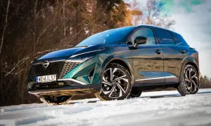 Zielony Nissan Qashqai Tekna na śniegu. Bogate wyposażenie tego SUV-a w zimowej scenerii.