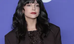 Maria Dębska, z partnerem u boku, prezentuje się elegancko w ciemnej marynarce i błyszczącej bluzce.
