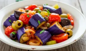 En härlig caponata med aubergine, tomater, oliver och kapris. Ett perfekt recept för en smakrik sallad.