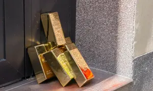 Złote sztabki opierają się o ciemne drzwi. Zastanawiasz się, gdzie sprzedać sztabkę złota?