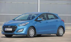 Niebieski Hyundai i30, gotowy do jazdy dziennej. Kierowca w okularach siedzi za kierownicą.