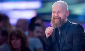 Alexander Bard, med sitt karaktäristiska skägg och skalliga huvud, ler och gestikulerar under ett event.