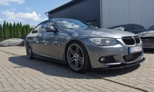 Szare BMW E92 335d z przyciemnianymi szybami i sportowym dyfuzorem, zaparkowane na zewnątrz.