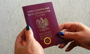Dwie dłonie trzymają polski paszport. Czy do Norwegii potrzebny jest paszport? Tak, jeśli podróżujesz spoza strefy Schengen.