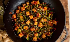 Salteado de verduras con tofu crujiente y sésamo en wok. Un plato vibrante y lleno de sabor.