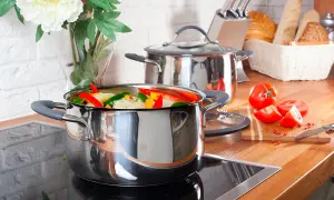 Casserole remplie de légumes colorés sur une plaque à induction, prête à être cuisinée.