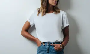 Frau in Jeans und einem weißen T-Shirt, das leicht gerollt ist. Das T-Shirt hat ein geringes Gewicht und ist bequem.