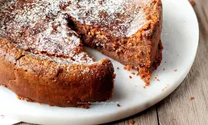 Torta soffice e golosa, uno dei tanti dolci con cioccolato al latte, spolverata di zucchero a velo su un piatto di marmo.