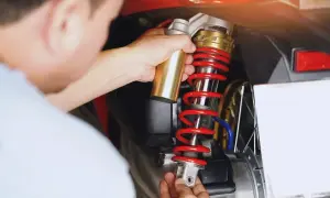 Mechanik wymienia amortyzator w skuterze. Sprawdź wymiana amortyzatorów cena, by zadbać o komfort jazdy.