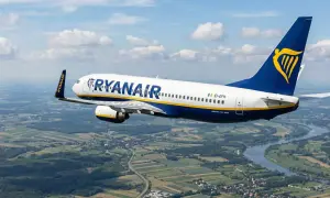 Samolot Ryanair leci nad zieloną krainą. Od kiedy loty tanich linii lotniczych stały się tak popularne?