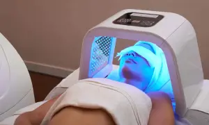 Une femme reçoit un traitement de luminothérapie visage, profitant des bienfaits de cette technologie pour une peau éclatante.