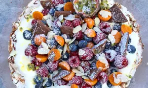 En härlig pavlova tårta fylld med färska bär, passionsfrukt, choklad och mandel.