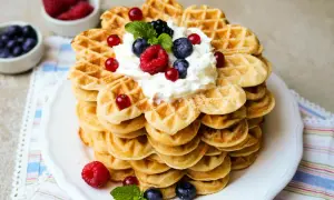 Ein Turm aus herzförmigen Waffeln, gekrönt mit Sahne und Beeren. Dieses waffelteig rezept ist ein Traum!