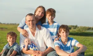 Szczęśliwa rodzina na łonie natury. Uśmiechnięci rodzice z czwórką dzieci, od niemowlaka po nastolatków. To piękna rejestracja kk.