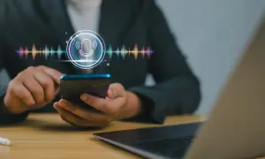 Osoba korzysta z telefonu, na ekranie widoczny jest symbol mikrofonu i wizualizacja dźwięku. Dowiedz się, jak nagrać rozmowę telefoniczną.