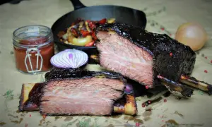 Zart geschmorte short ribs, glasiert und saftig, mit Beilagen wie Zwiebeln und Sauce.