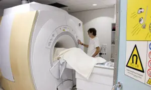 Un technicien prépare un patient pour une IRM. La question "combien d'IRM peut-on faire par an" dépend de la prescription médicale.