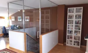 Modern glass enclosure around open stairs, creating a safe and stylish way como cerrar escaleras abiertas.