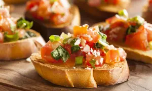 Frisches Bruschetta Rezept: geröstetes Brot mit Tomaten, Basilikum und Parmesan. Köstlich und einfach zuzubereiten!