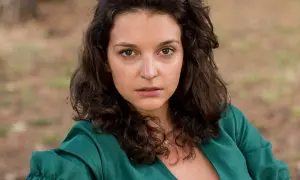 Maria Dębska w zielonej sukience, aktorka znana z wielu filmów, patrzy wprost na widza.