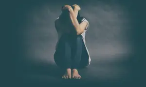 Osoba skulona, z rękami na głowie, symbolizuje walkę z depresją lekooporną.