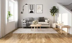 Ljust golv inspiration i ett modernt vardagsrum med grå soffa, rund soffbord och en stor grön växt.