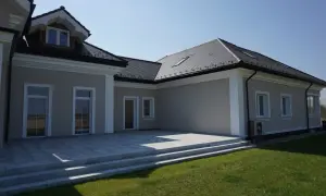 Nowoczesny dom z tarasem i schodami. Elegancki gzyms podkreśla architekturę budynku.