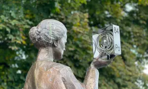 Pomnik Marii Skłodowskiej-Curie w Polsce, trzymająca symbol polonu (Po).