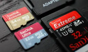 Karty pamięci SanDisk Extreme i Ultra, w tym 64GB microSDXC i 32GB microSDHC, obok adaptera. Różnice między SDXC a SDHC są widoczne.