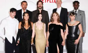 Cała obsada serialu "Emily w Paryżu" pozuje do zdjęcia na ściance Netflix.