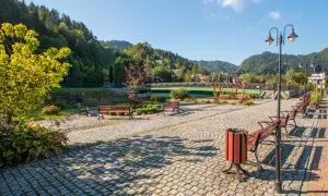 Urokliwa promenada nad Grajcarkiem, z ławkami i latarniami, zaprasza do spacerów wśród zieleni i górskiego krajobrazu.