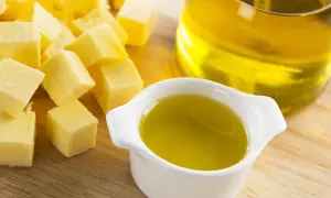 Würfel von Butter und ein Schälchen mit Öl. Fette Chemie für köstliche Gerichte.