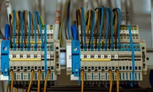 Zaciski elektryczne z kolorowymi przewodami, gotowe do podłączenia licznika prądu.