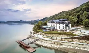 Nowoczesny hotel nad jeziorem, idealny na romantyczne miejsca w Polsce. Widok na wodę, las i pomost.